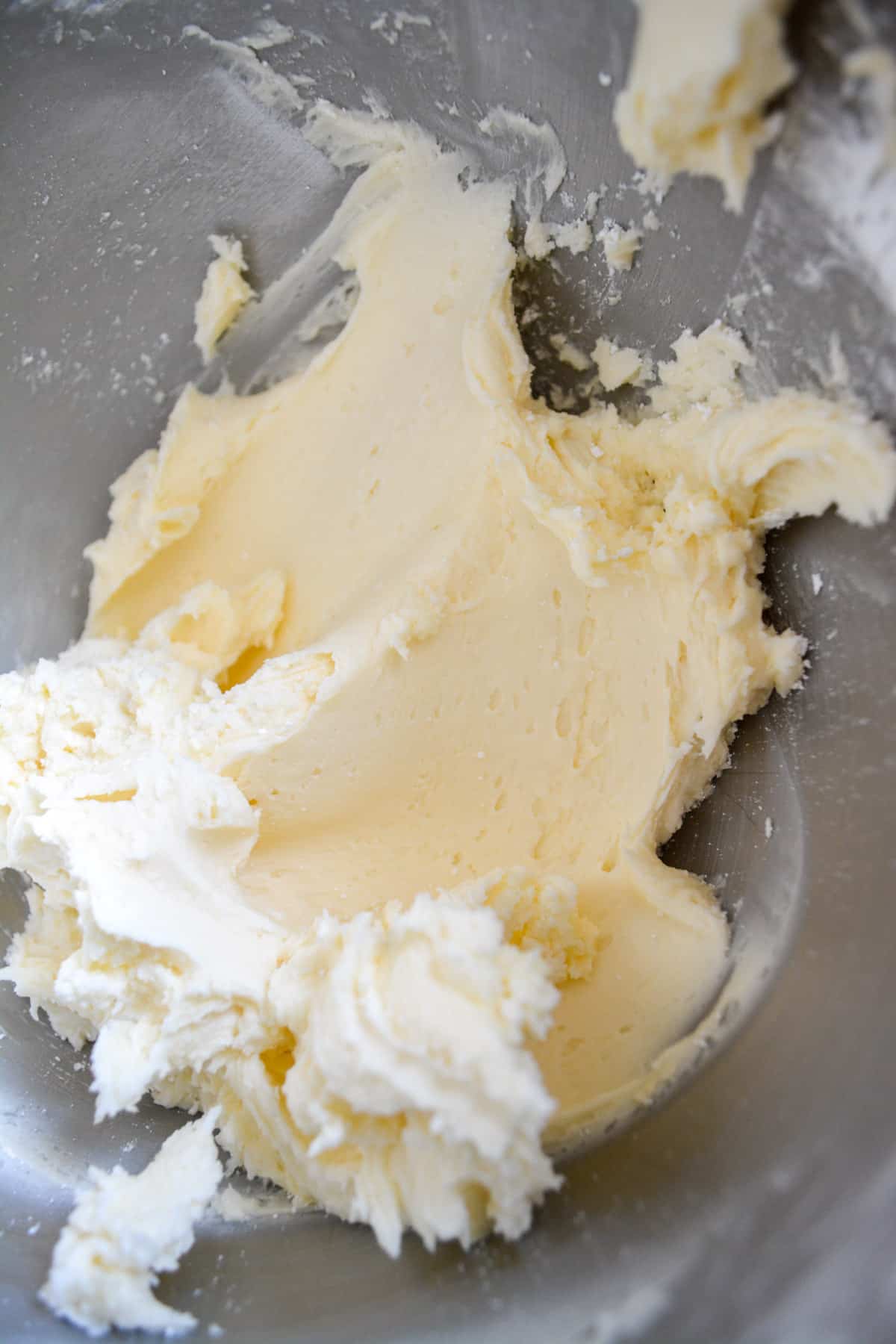 Mixing dairy-free buttercream frosting in a metal bowl.