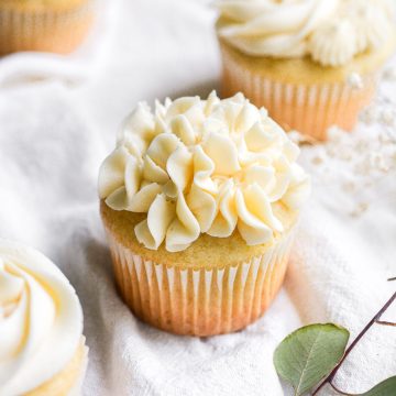 A cupcake with vegan vanilla buttercream frosting piped on top.