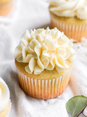 A cupcake with vegan vanilla buttercream frosting piped on top.