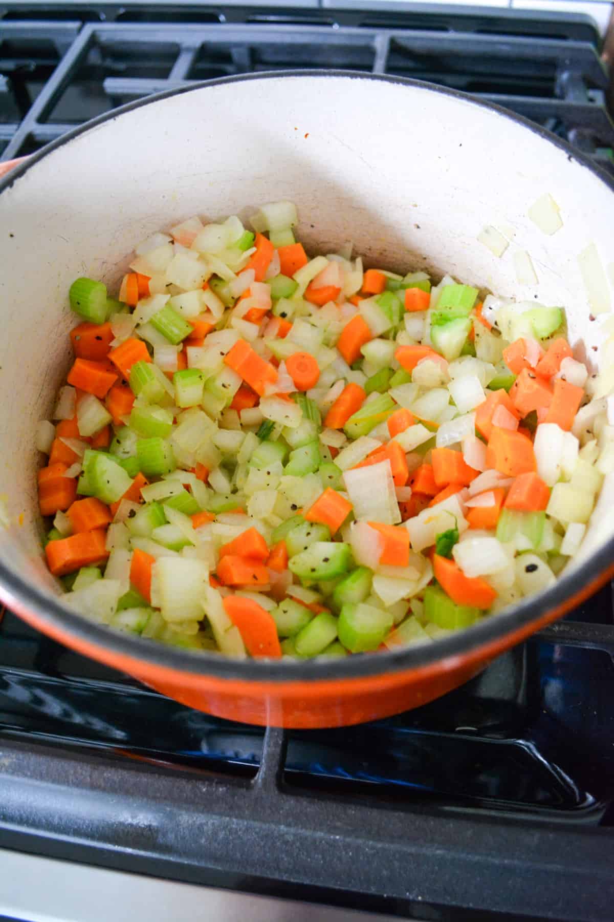 Garlic added into the pot of softened onion, carrot and celery.