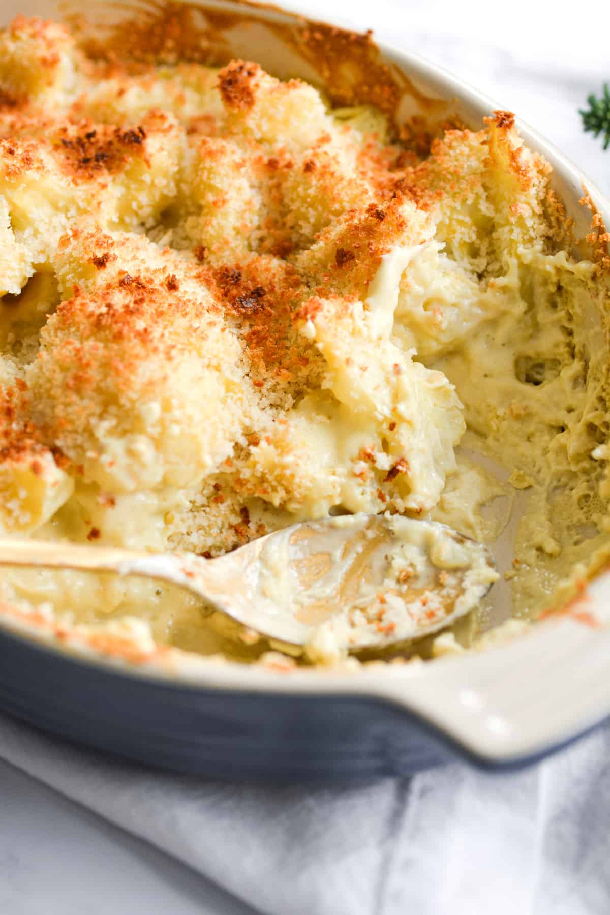 A scoop taken out of the baked vegan cheesy cauliflower casserole.