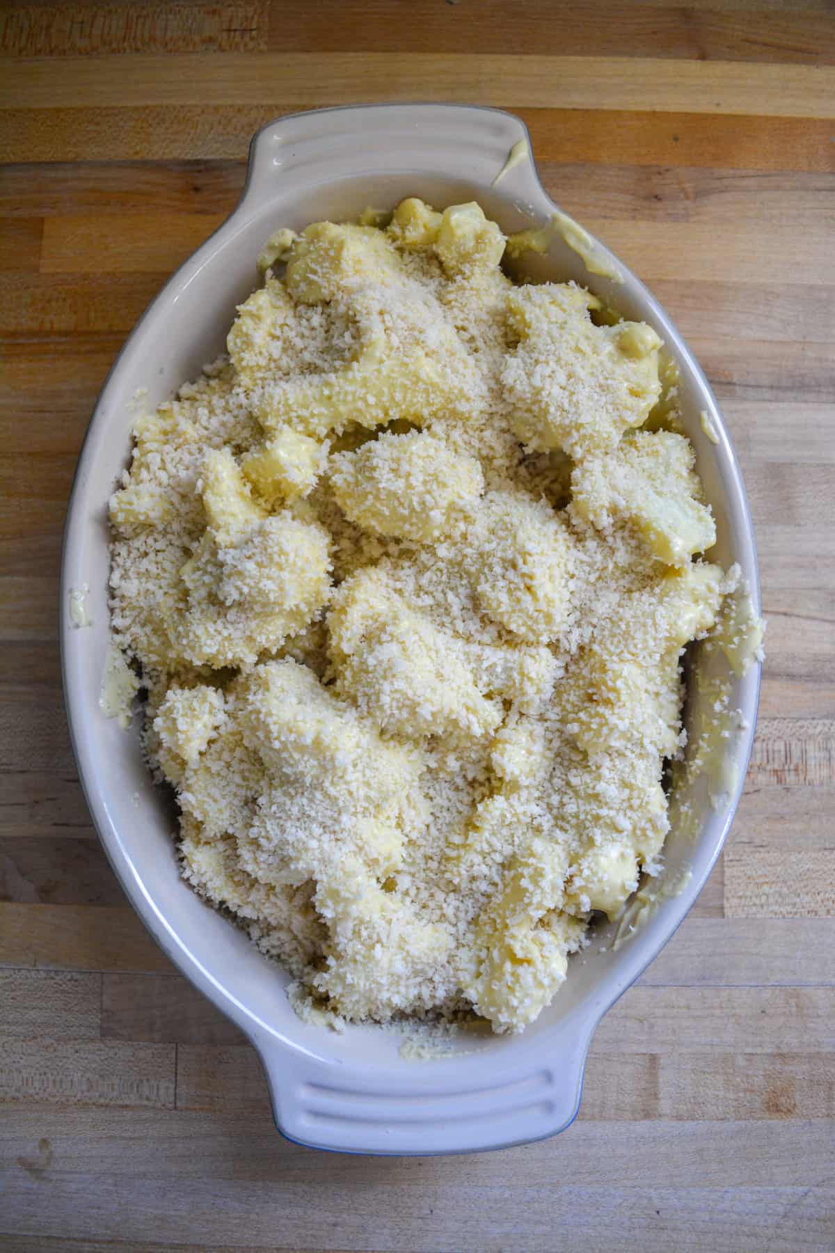 Overhead shot of the cheesy cauliflower in a baking dish toped with panko breadcrumbs.