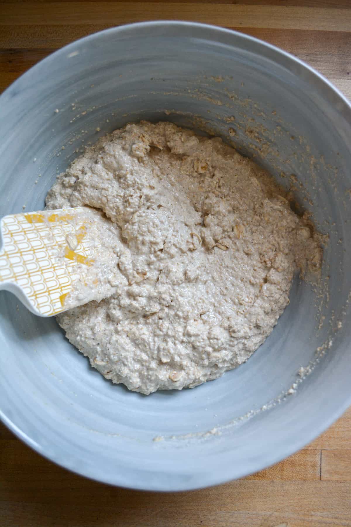 Homemade oat flour and rolled oats soaking in non-dairy milk in a mixing bowl.