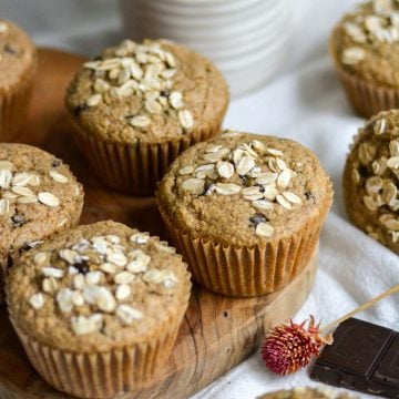 Vegan and Gluten Free Oat Flour Chocolate Chip Muffins on a small wooden cutting board.