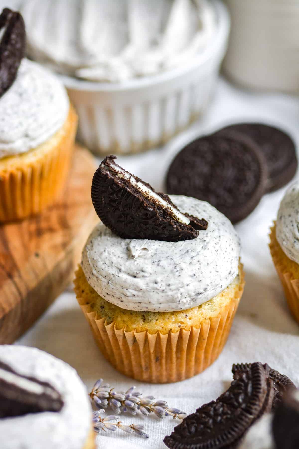 Vegan Oreo Cupcake with Oreo Frosting on a white cloth with other cupcakes in the background.