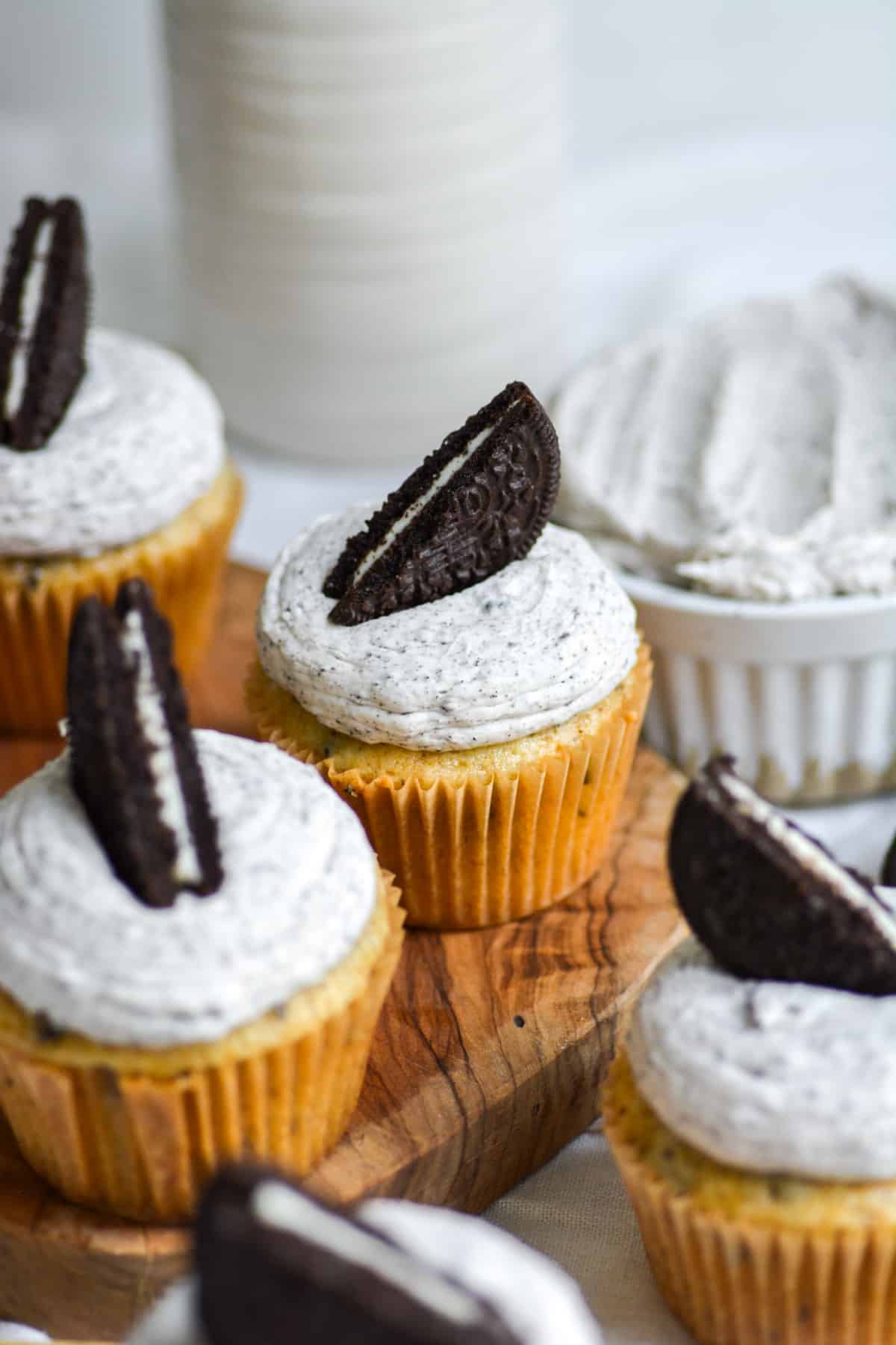 Cookies and cream cupcakes topped with an oOeo on a wooden board. 