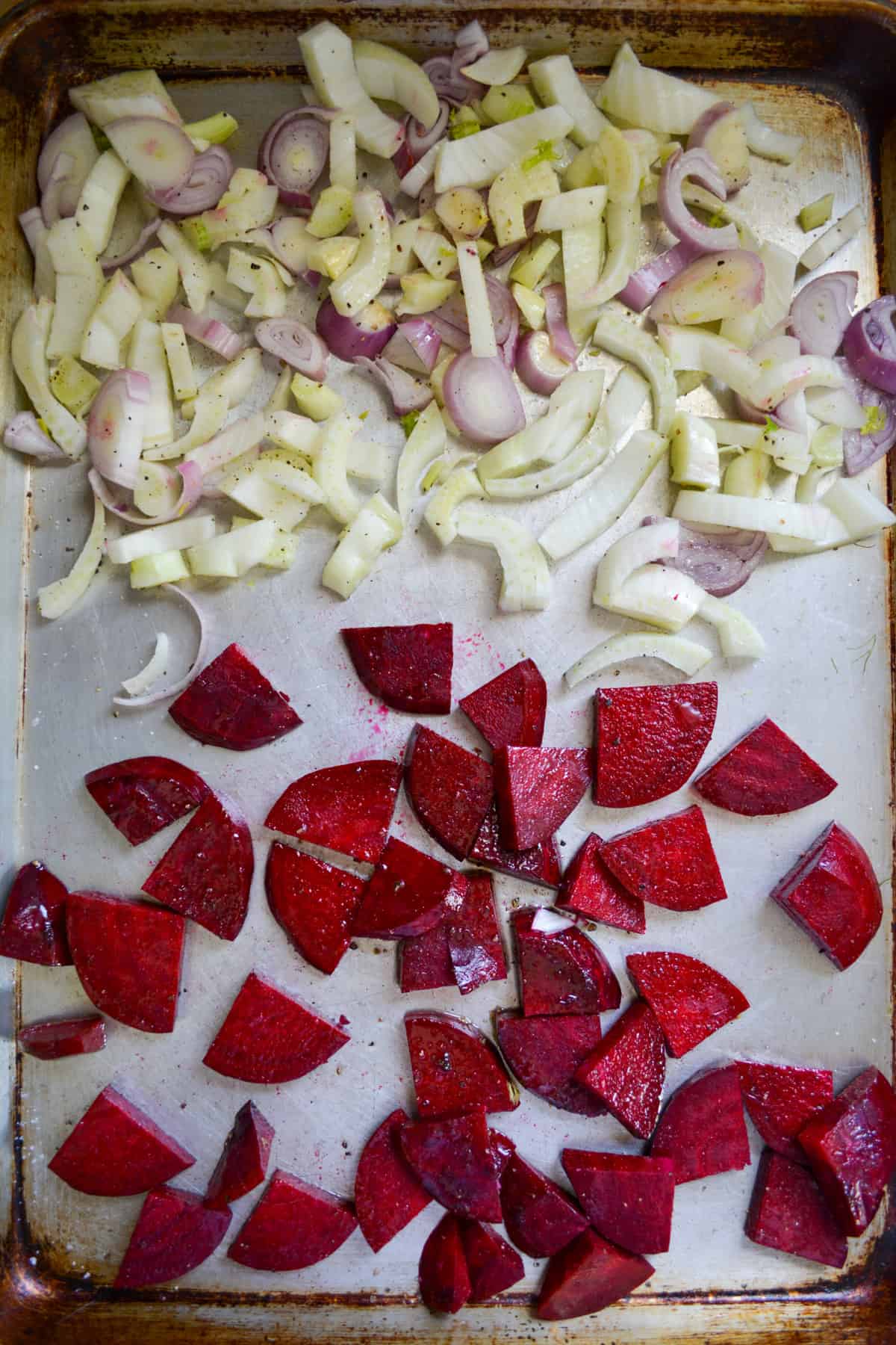 Sliced beets, fennel and shallot on a baking sheet.