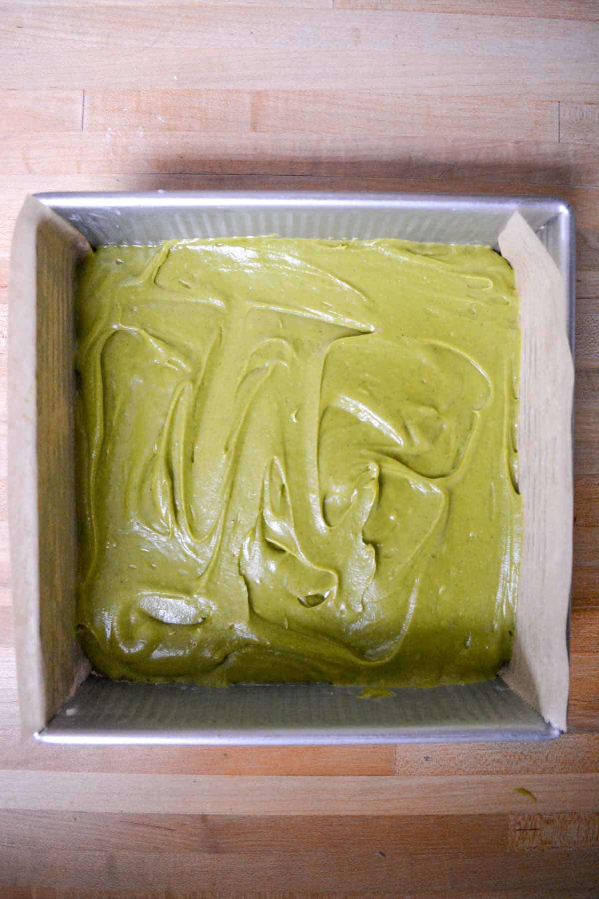 Green tea matcha cake batter in a square baking pan.