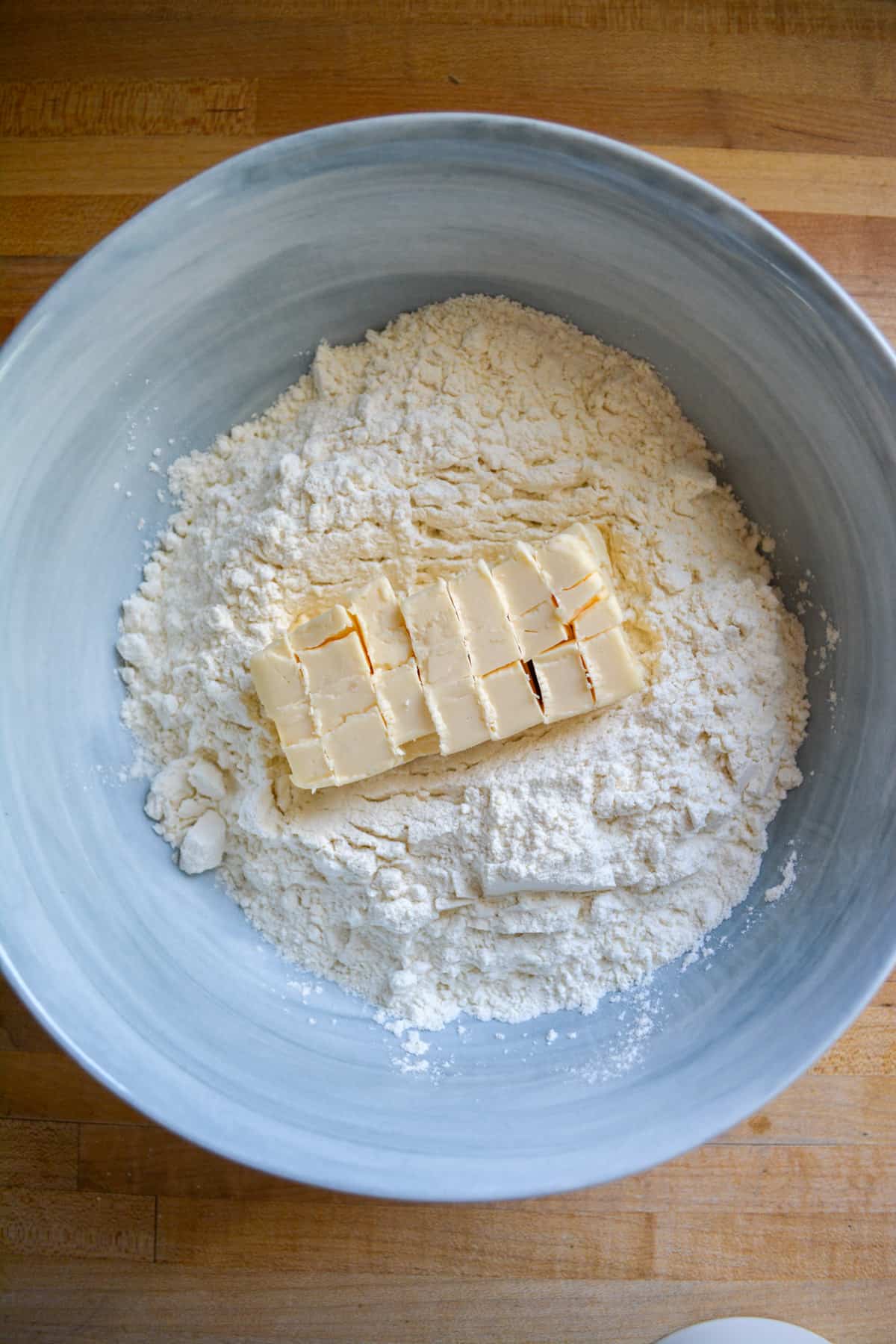 Cubed butter in a bowl with dry ingredients.