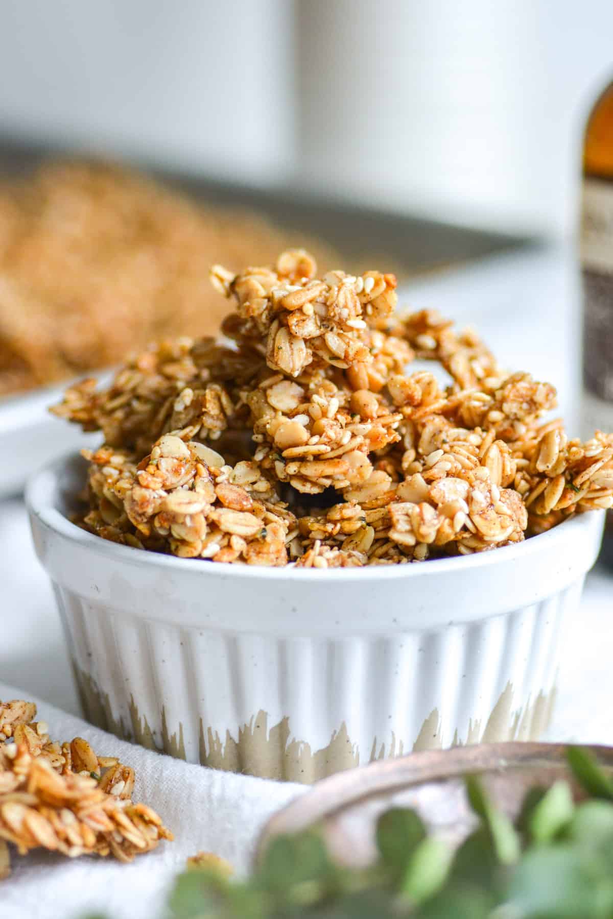 Clusters of homemade cinnamon granola with no nuts in a white ramekin.