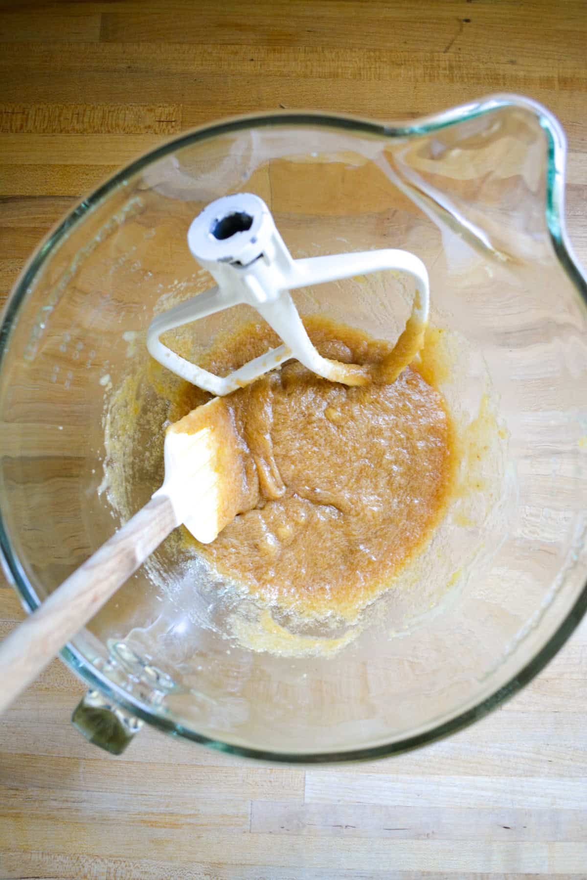 Mashed banana added to the creamed mixture in a glass bowl.