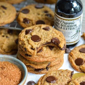 A stack of Vegan Banana Chocolate Chip Cookies with a bite taken out of the top cookie.