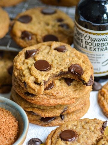 A stack of Vegan Banana Chocolate Chip Cookies with a bite taken out of the top cookie.