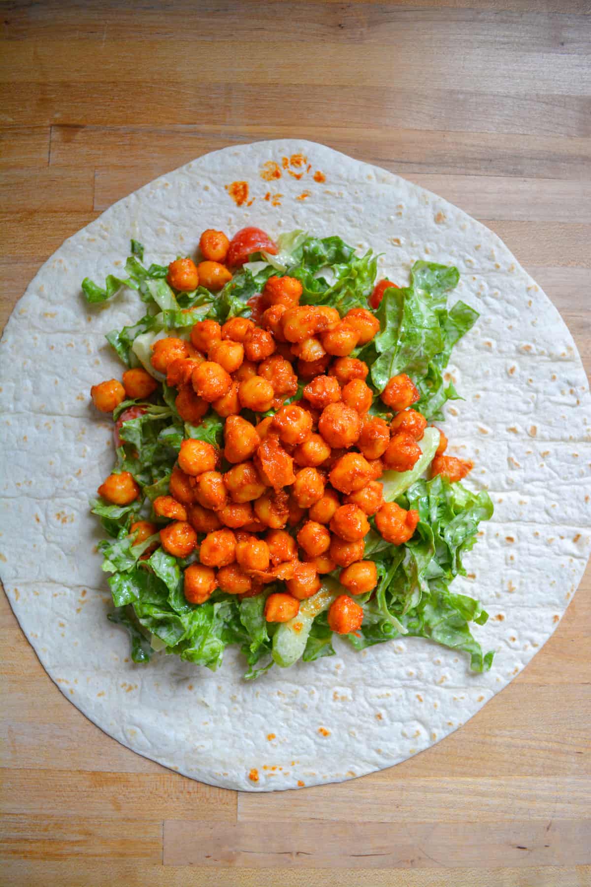 A wrap topped with the ranch salad and buffalo chickpeas.