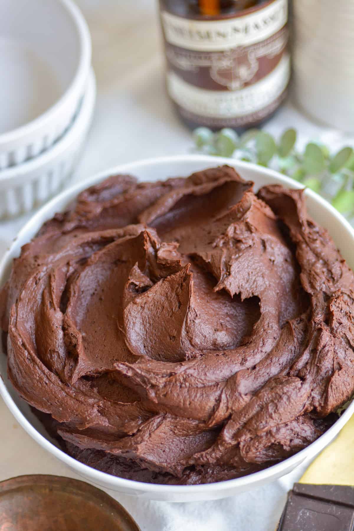 Vegan Chocolate Buttercream Frosting in a white bowl on a white cloth.
