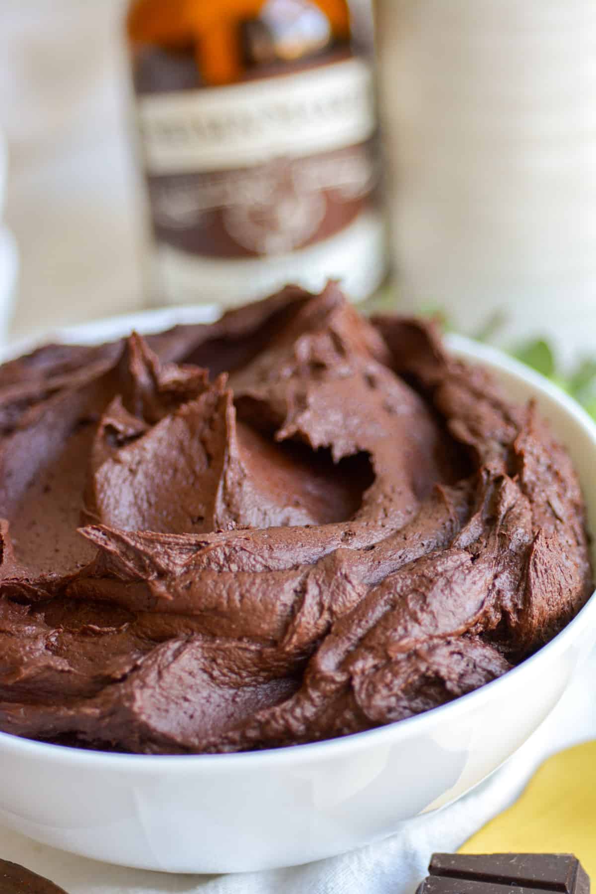 Close up of vegan chocolate buttercream frosting in a white bowl.