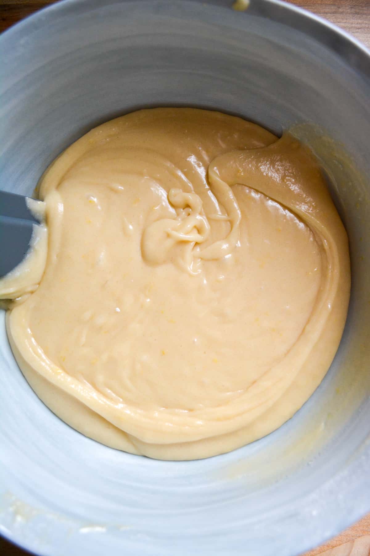 Dairy free and eggless Vegan Lemon Cake batter in a mixing bowl with a rubber spatula in it.