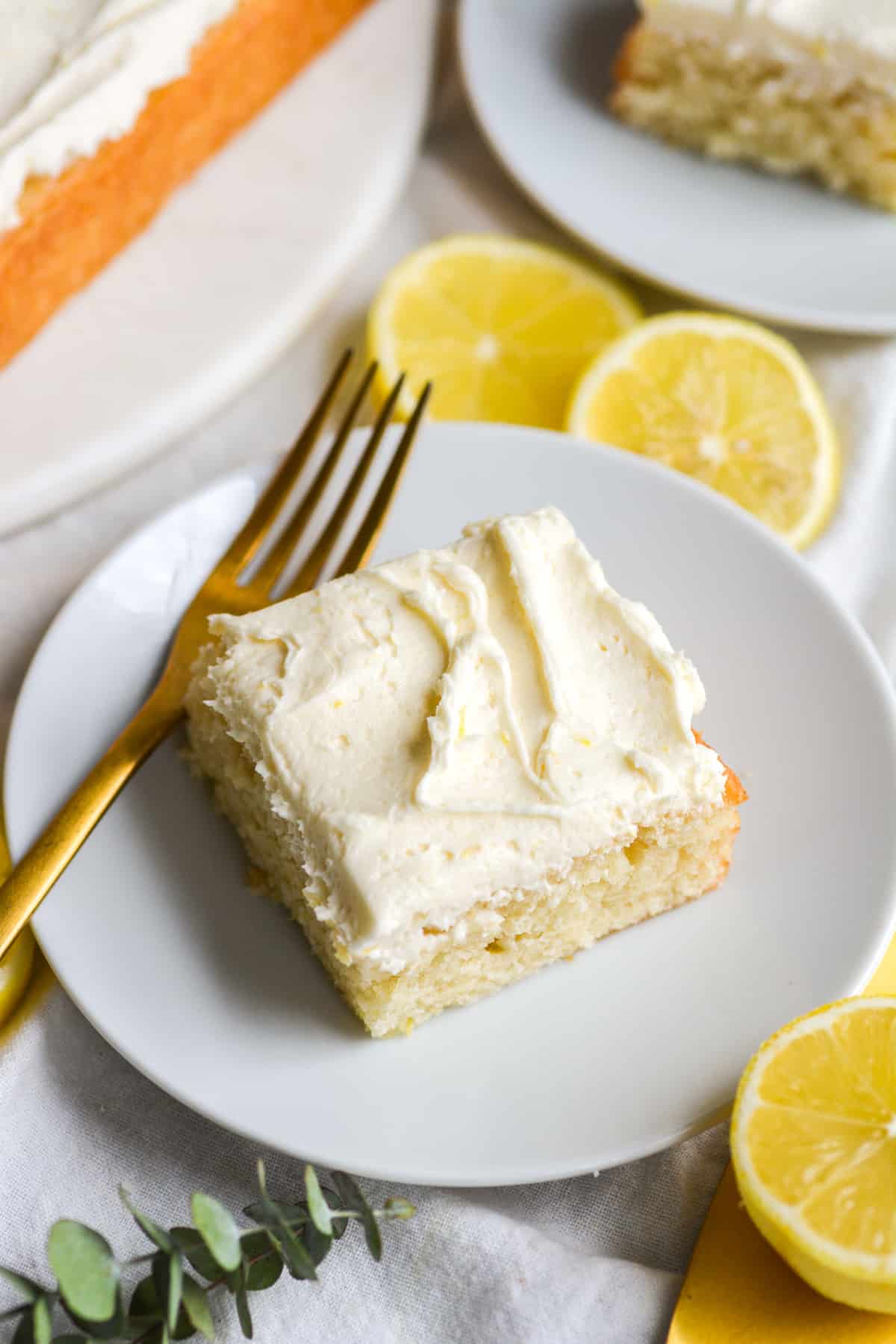 Eggless and dairy free Vegan Lemon cake on a white plate with a gold fork.