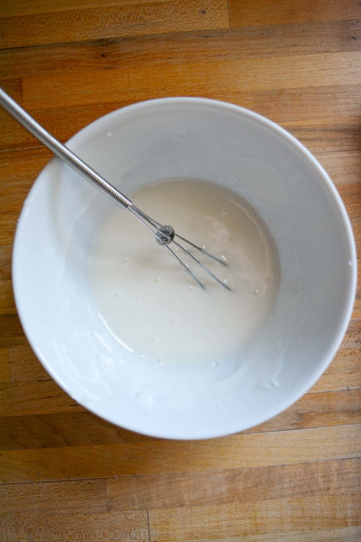 Lemon icing in a white bowl.