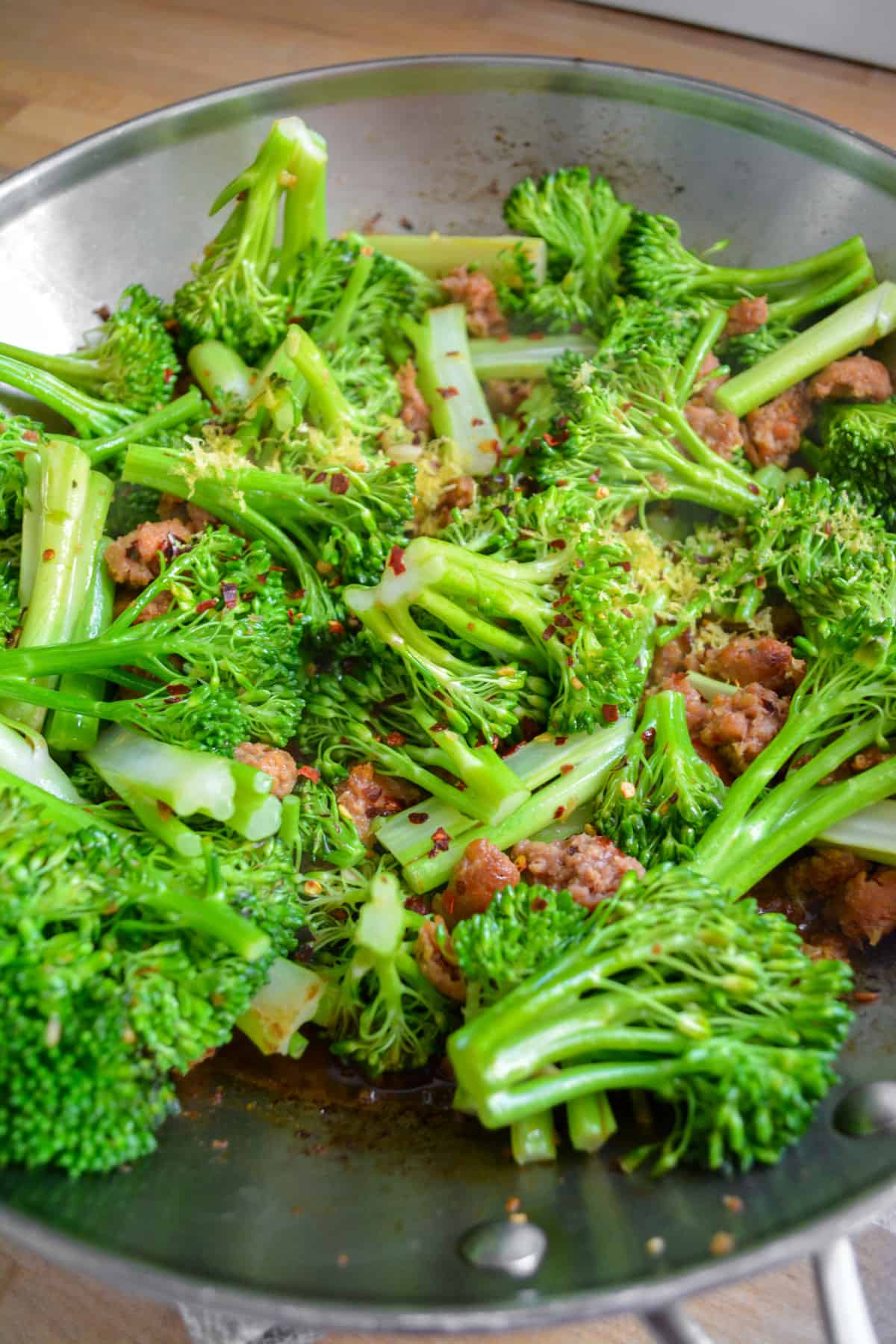 Lemon zest, vegetable stock and red pepper flakes added on top of the broccolini in a large skillet.