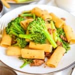 Vegan Sausage Pasta with Broccolini on a beige plate.