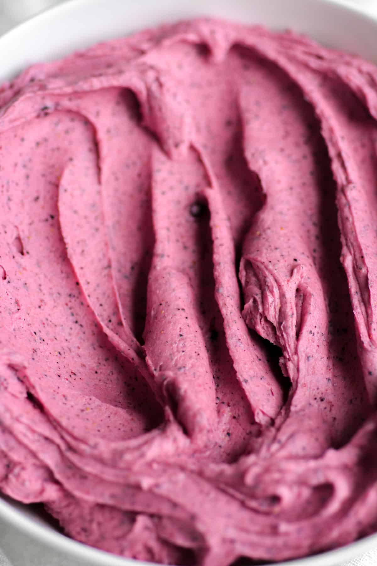 Blueberry buttercream frosting in a bowl.