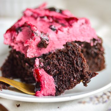 A fork with a bite of chocolate blueberry cake on it.