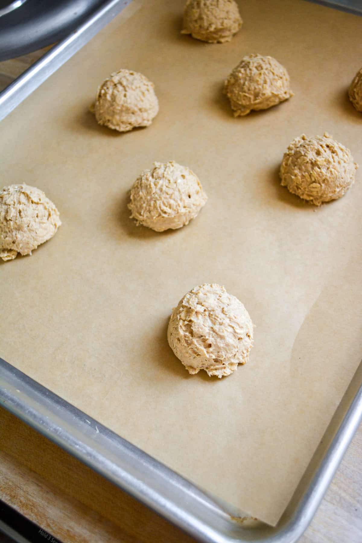 Cookie dough scooped onto a parchment-lined baking sheet.