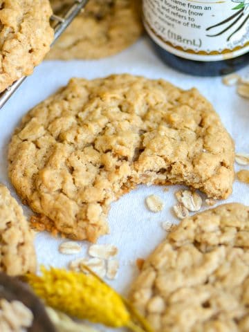A Peanut Butter Oatmeal Cookie with a bite taken out of it on a linen cloth.