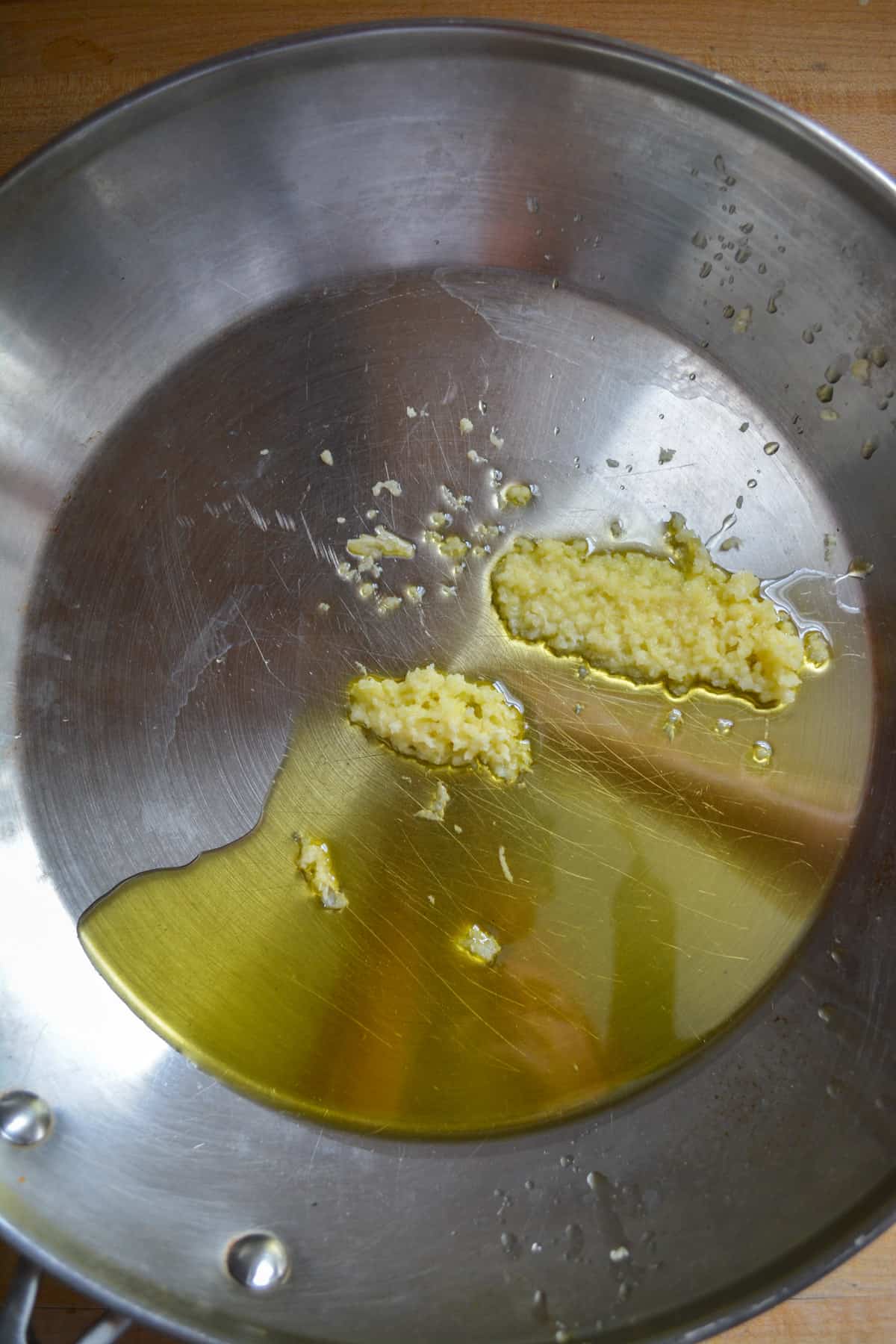 Olive oil and garlic in a stainless steel skillet.