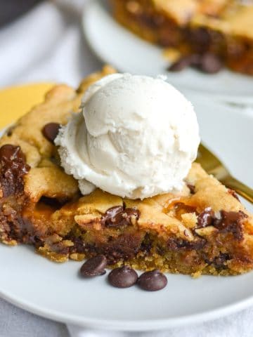 Vegan Salted Caramel Chocolate Chip Cookie Skillet flice on a white plate topped with ice cream.