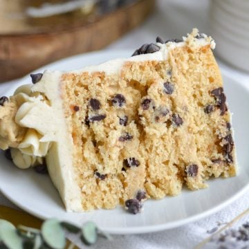 A slice of Vegan Chocolate Chip Cookie Dough Cake on a white plate.