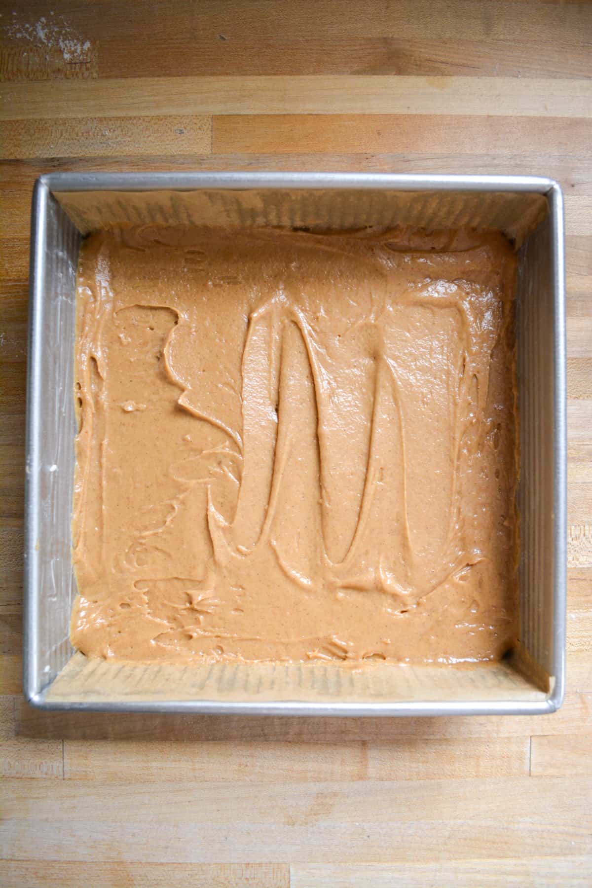 Cake batter spread out in a square pan.