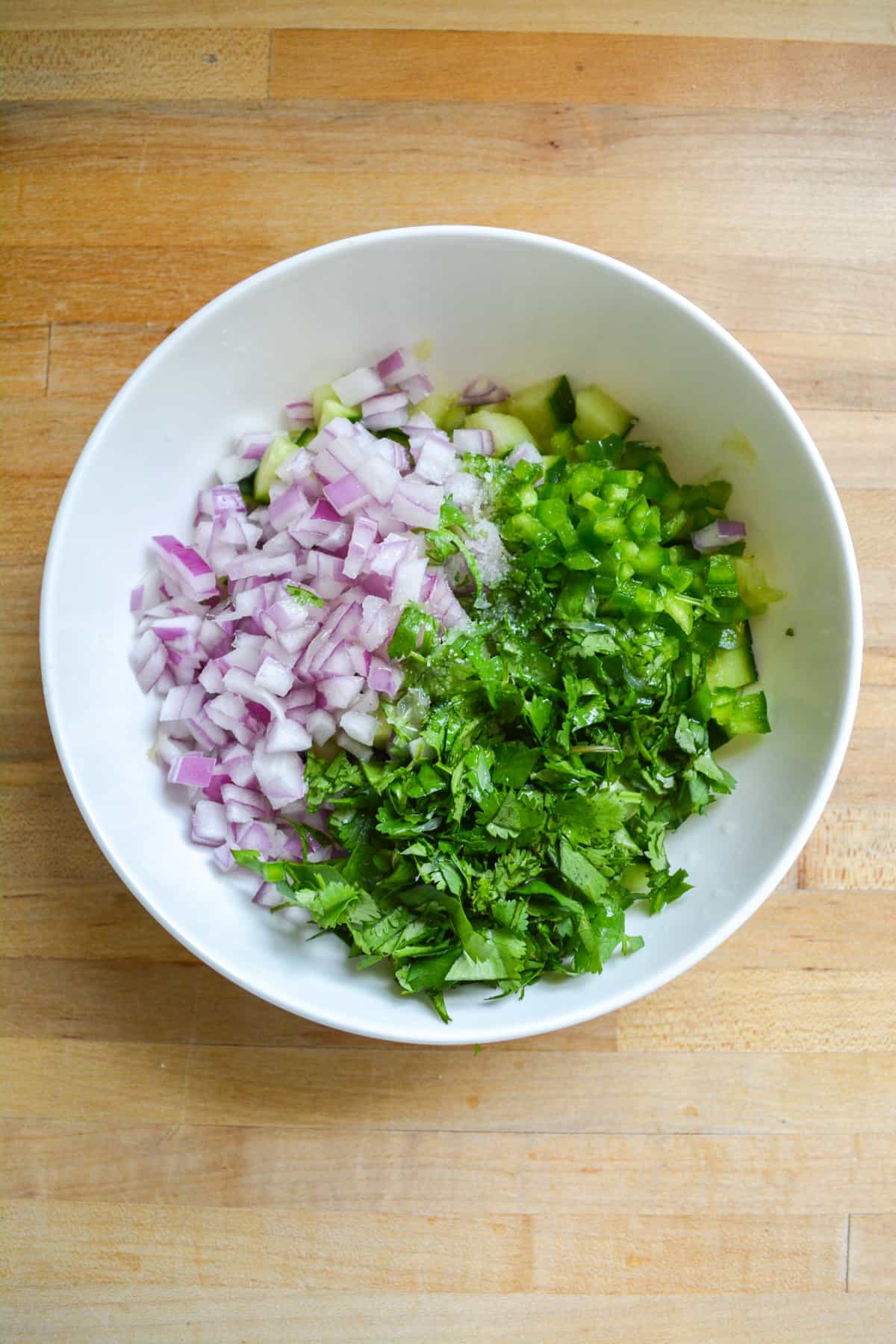 The cucumber pico de gallo ingredients in a bowl.