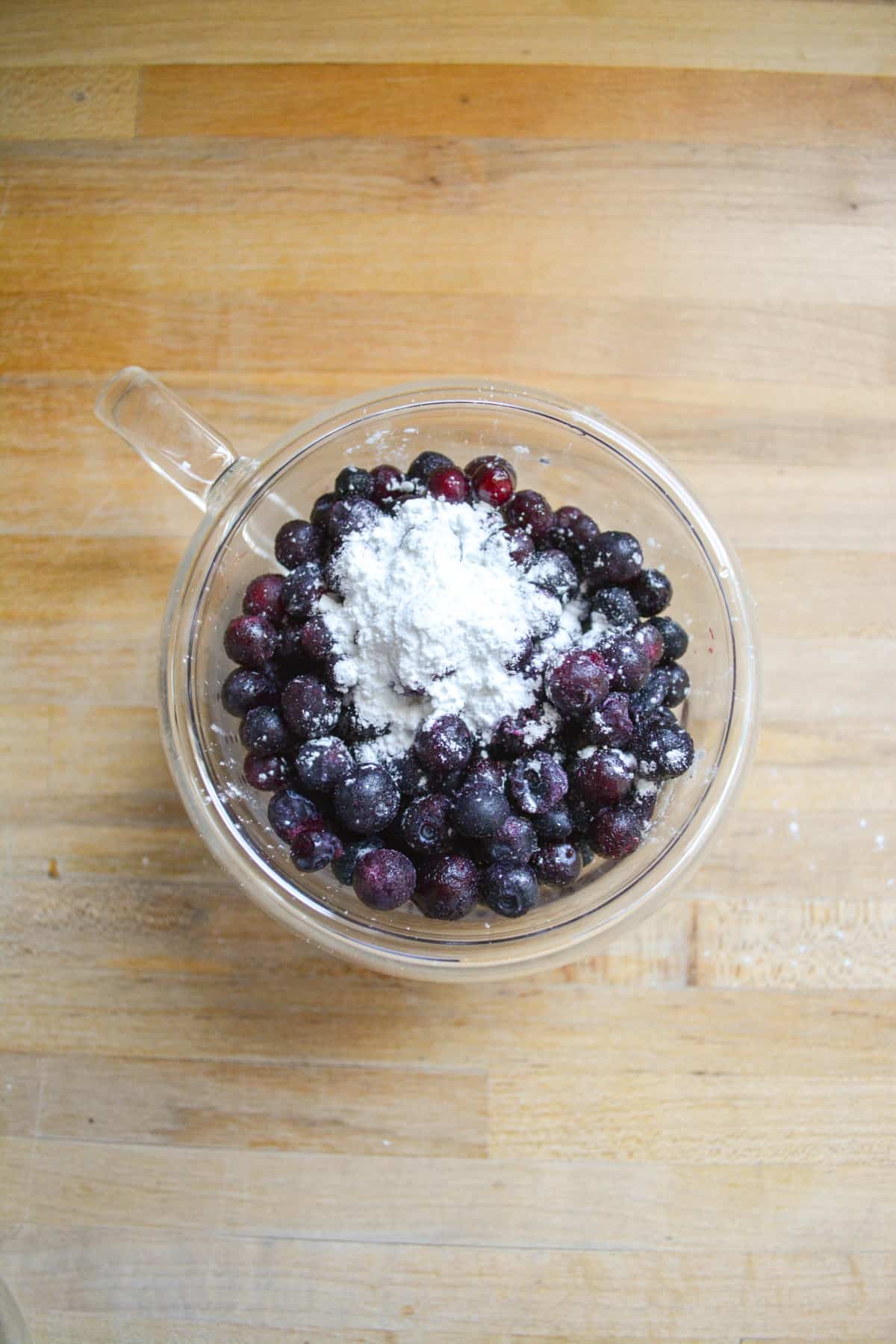 Blueberries in a small glass cup topped with cornstarch.