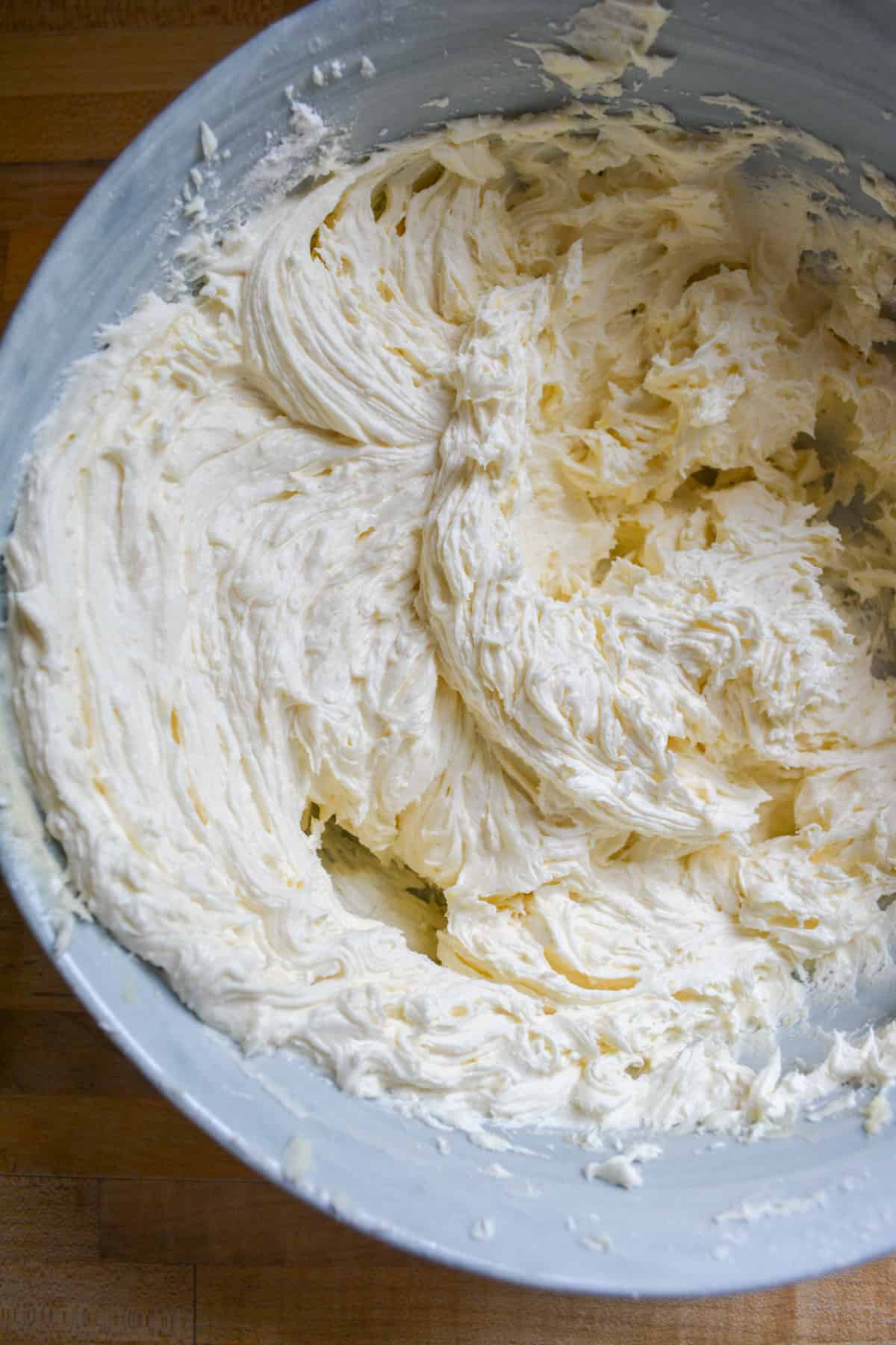 Fluffy lemon frosting in a large mixing bowl.