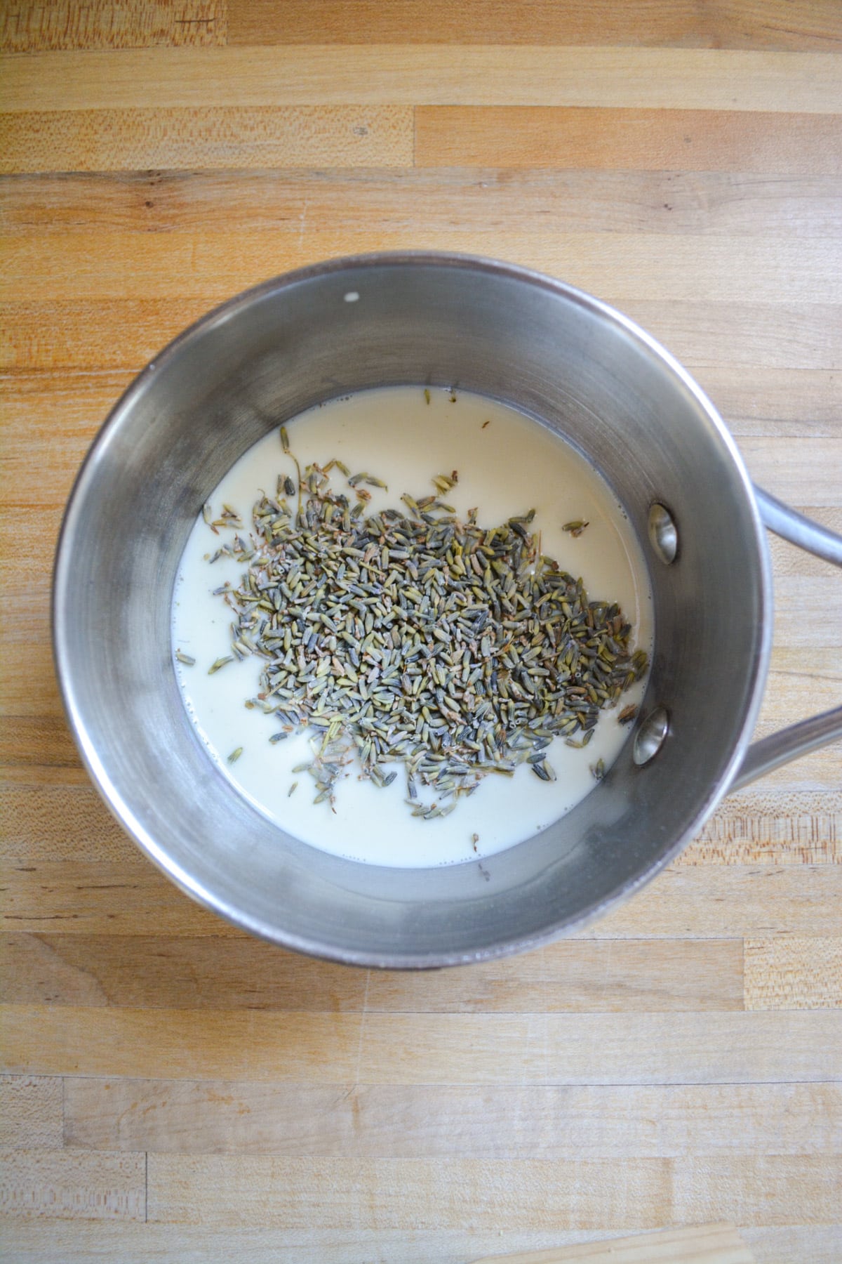 Dried lavender flowers and non-dairy milk in a small saucepan.