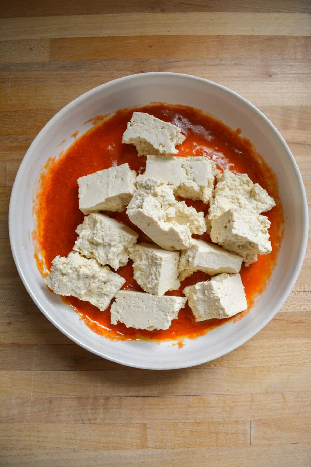Ripped tofu chunks in the bowl with the buffalo sauce.