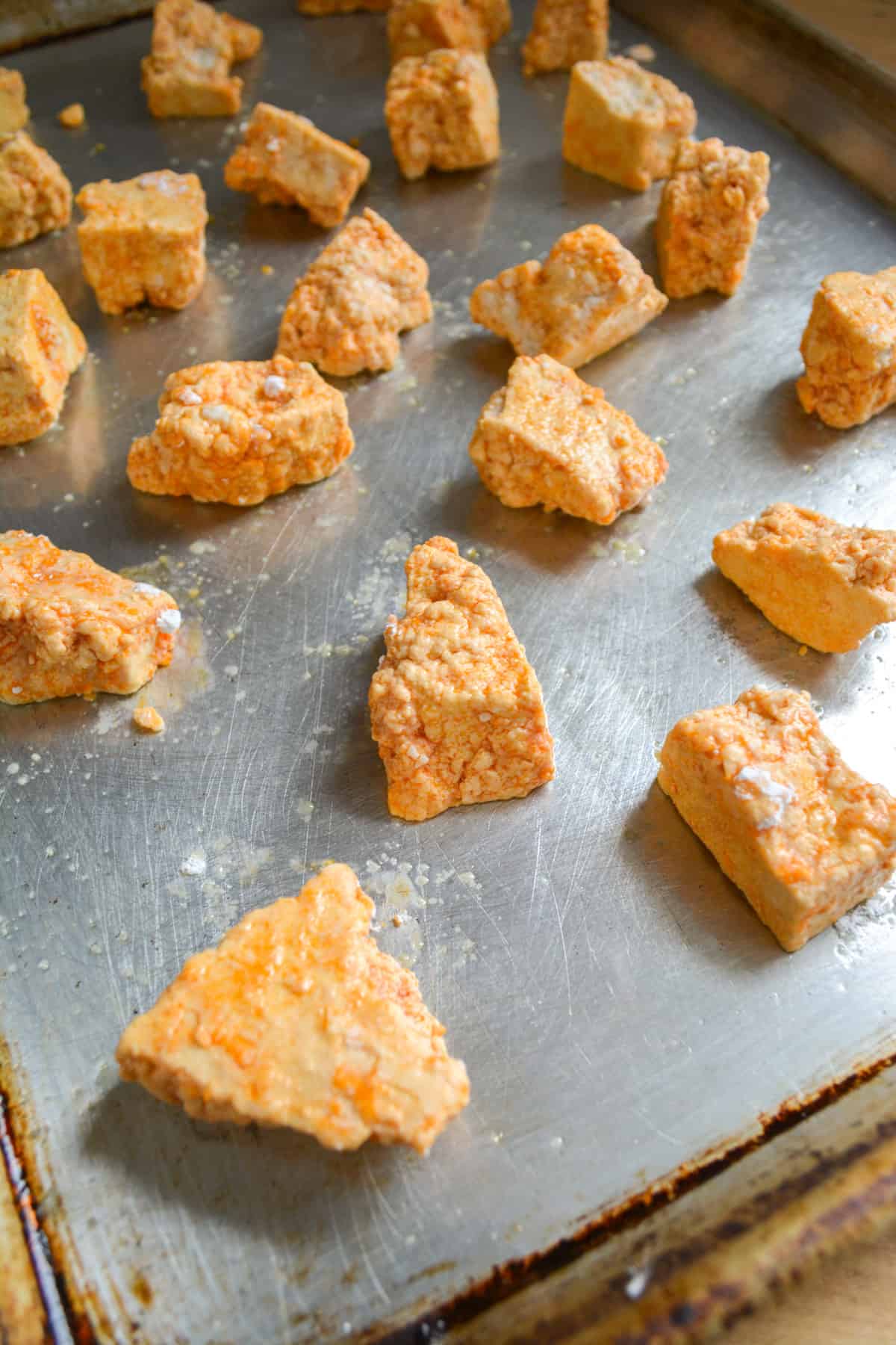 Tofu nuggets on a baking sheet.
