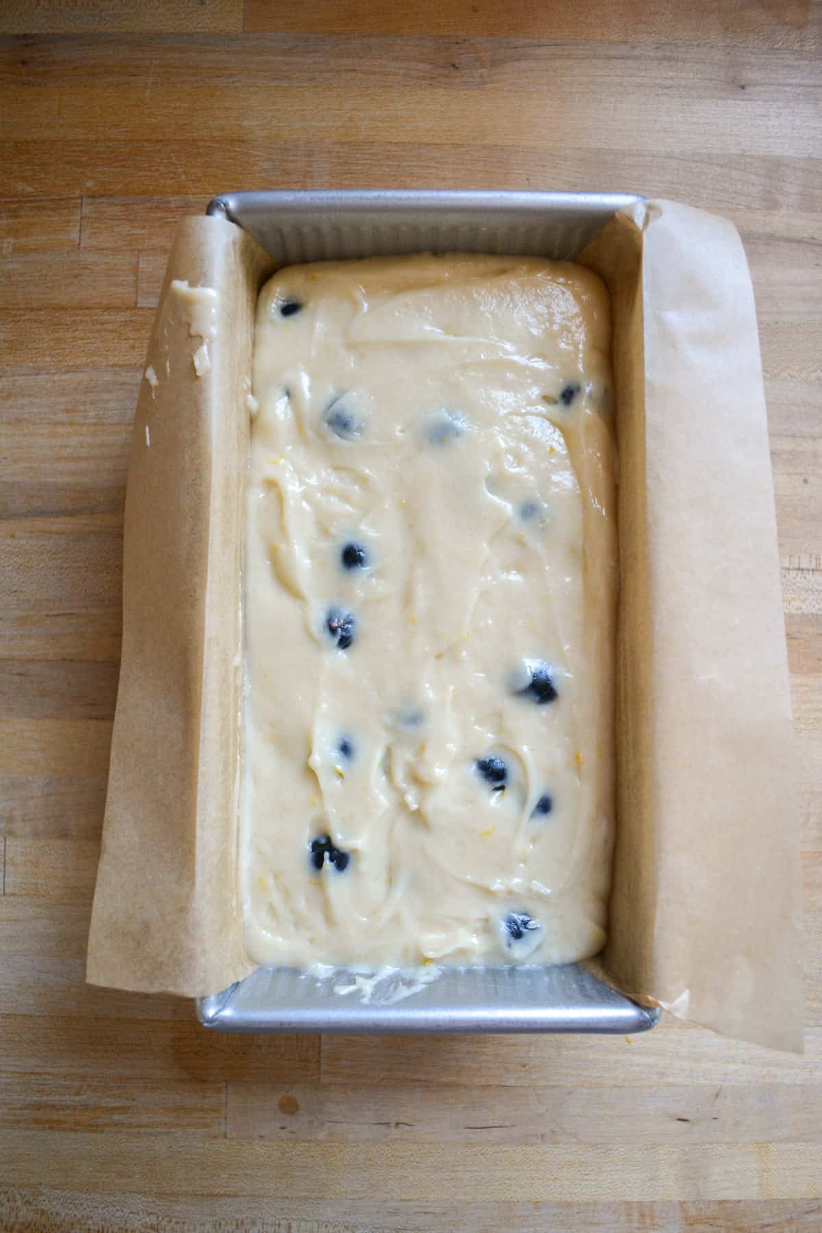 Lemon Blueberry cake batter in a prepared loaf pan.
