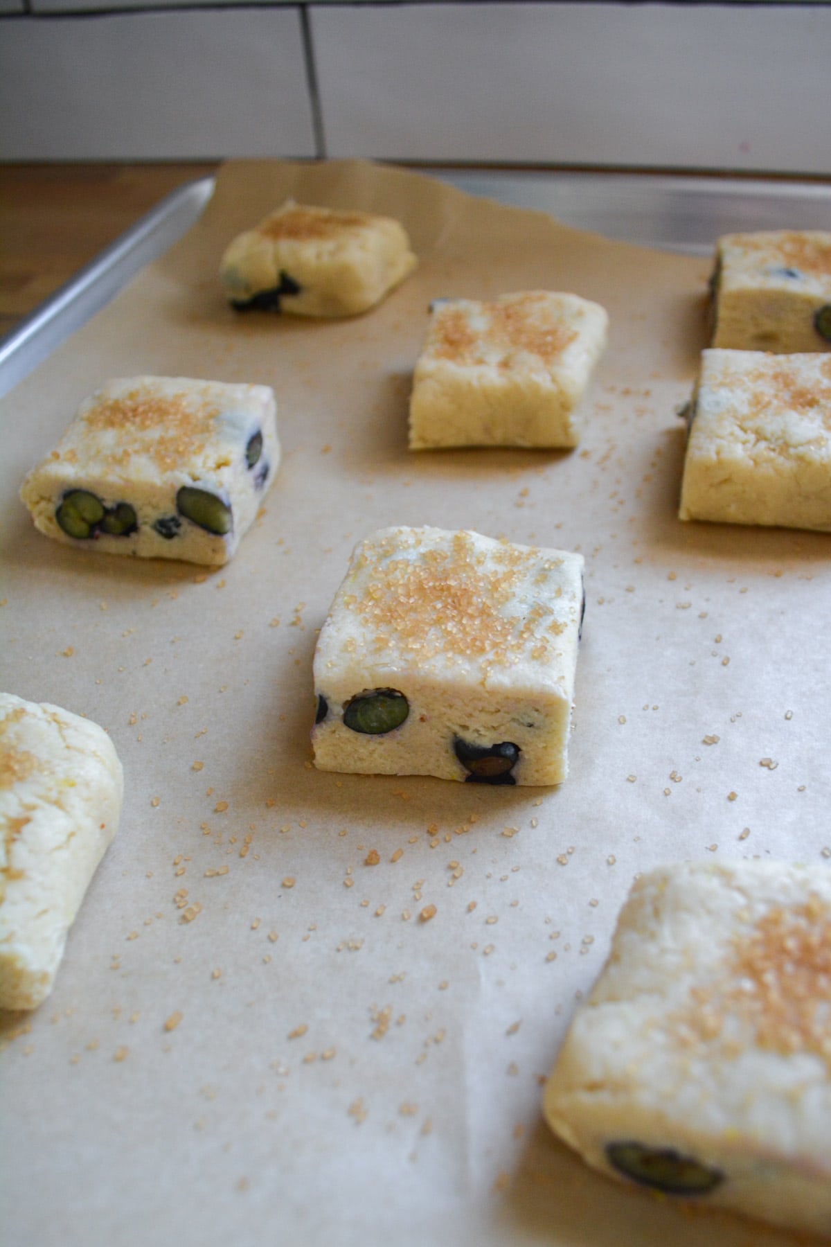 Cut scones placed onto a parchment lined baking sheet ready to bake.