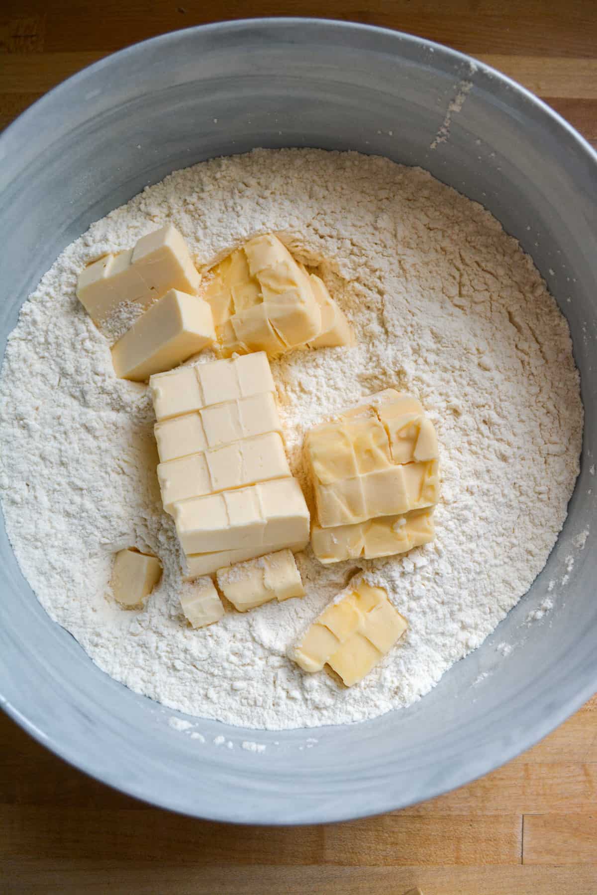Cubed vegan butter in a large mixing bowl with flour.