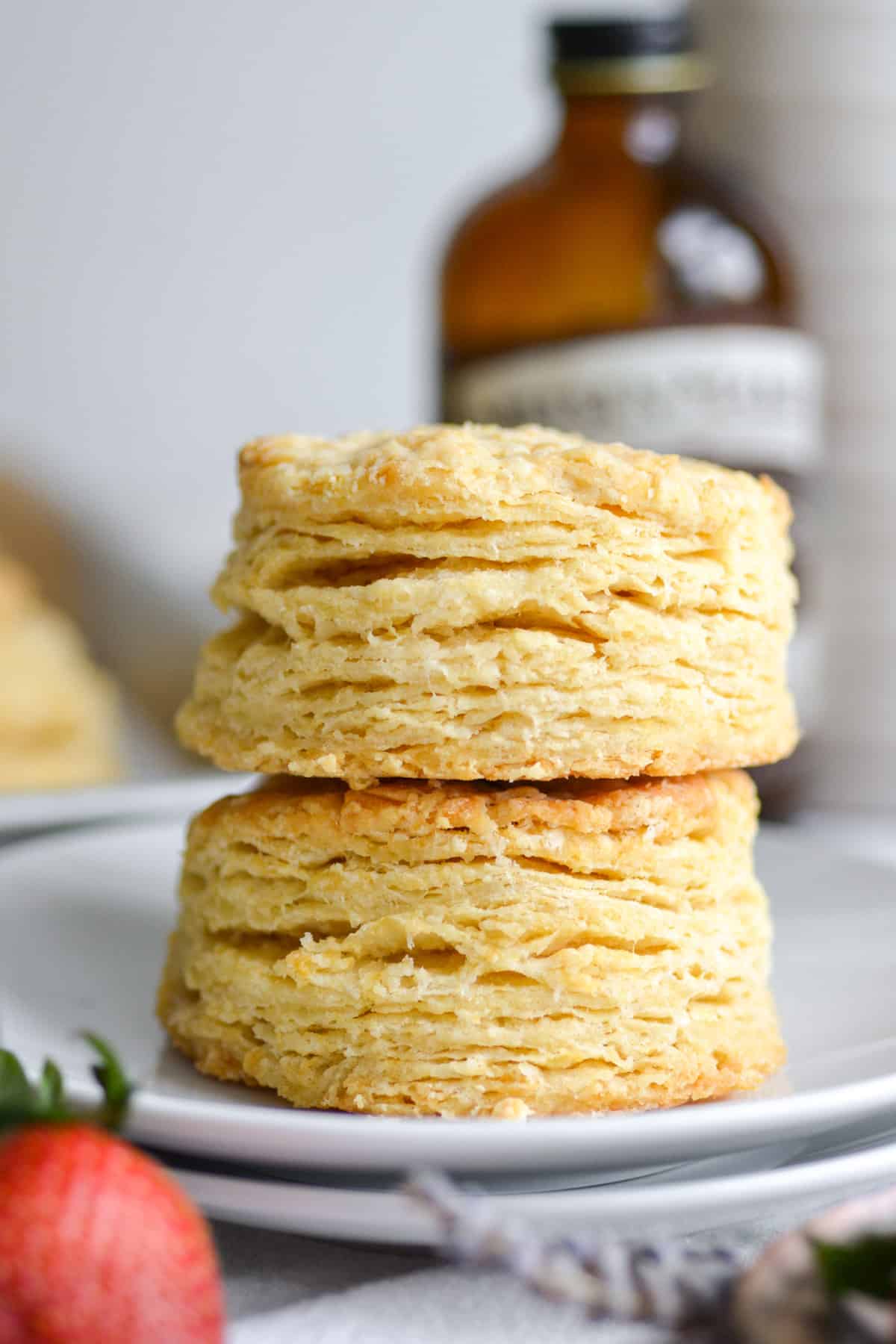 Two vegan and dairy free buttermilk biscuits stacked on each other on a small plate.