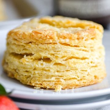 A flaky Vegan Dairy Free Buttermilk Biscuit on a white plate.