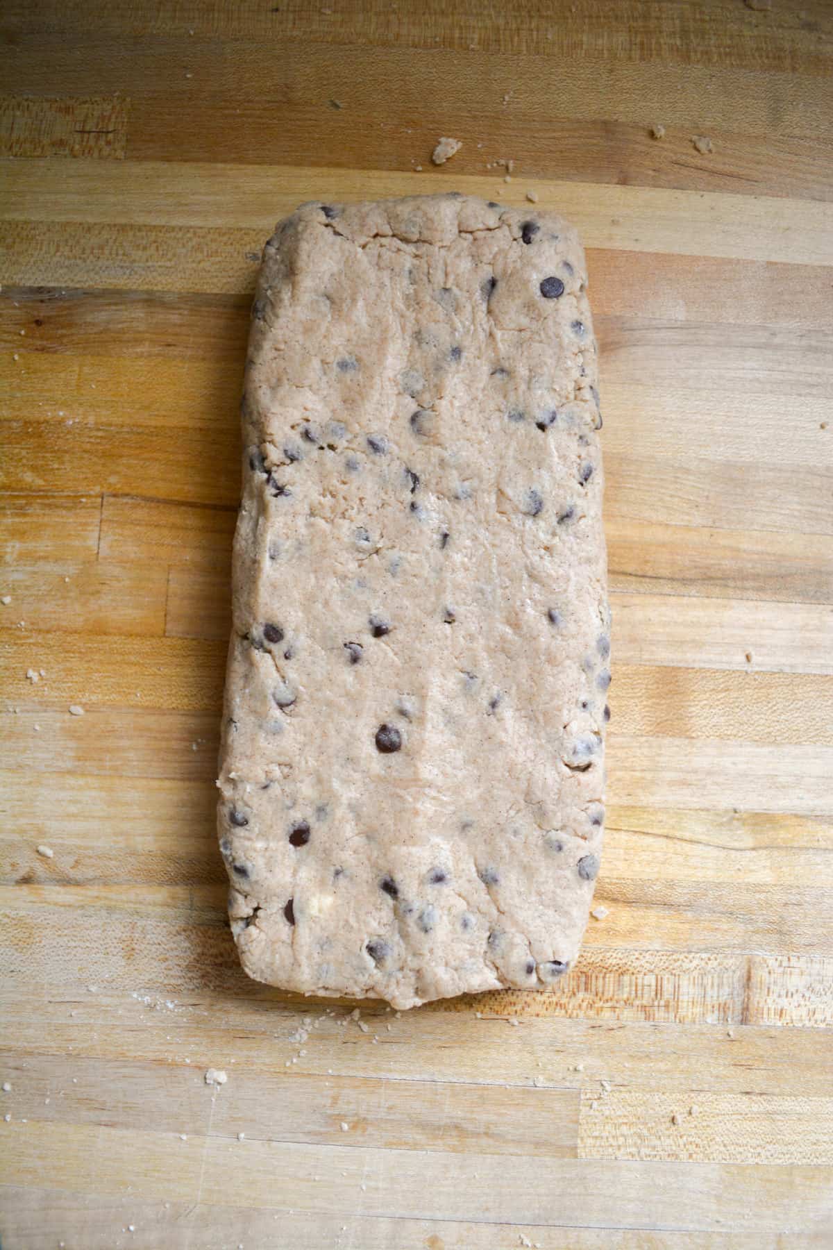 Scone dough patted into a rectangle on a wooden surface.