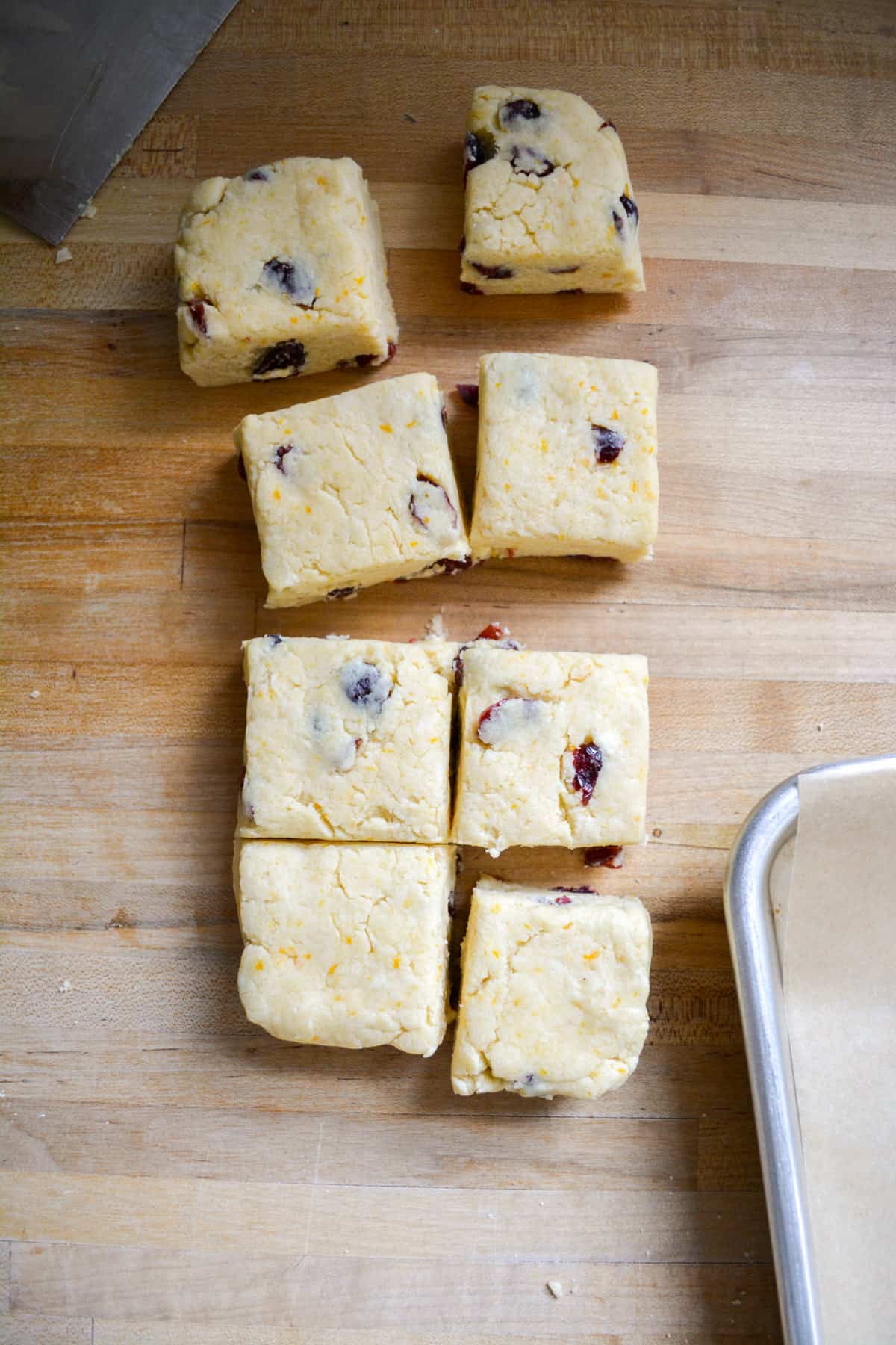 Vegan Cranberry Scone Dough pressed out into a rectangle and cut into squares.