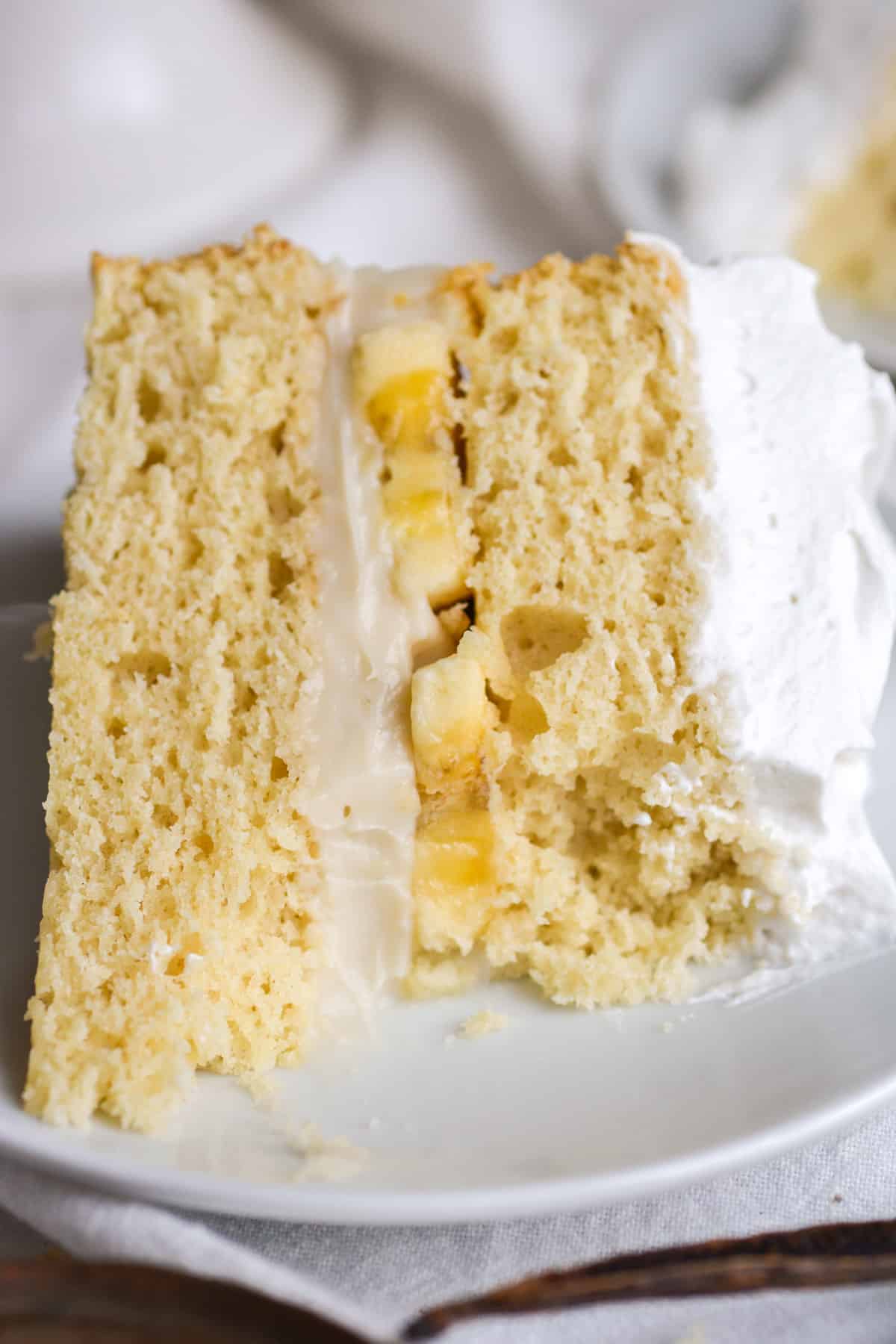 A slice of cake with the non-dairy vegan pastry cream custard in the middle of the cake layers.