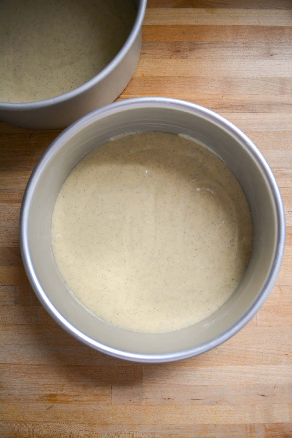 Cake batter portioned out into two eight inch round cake pans.