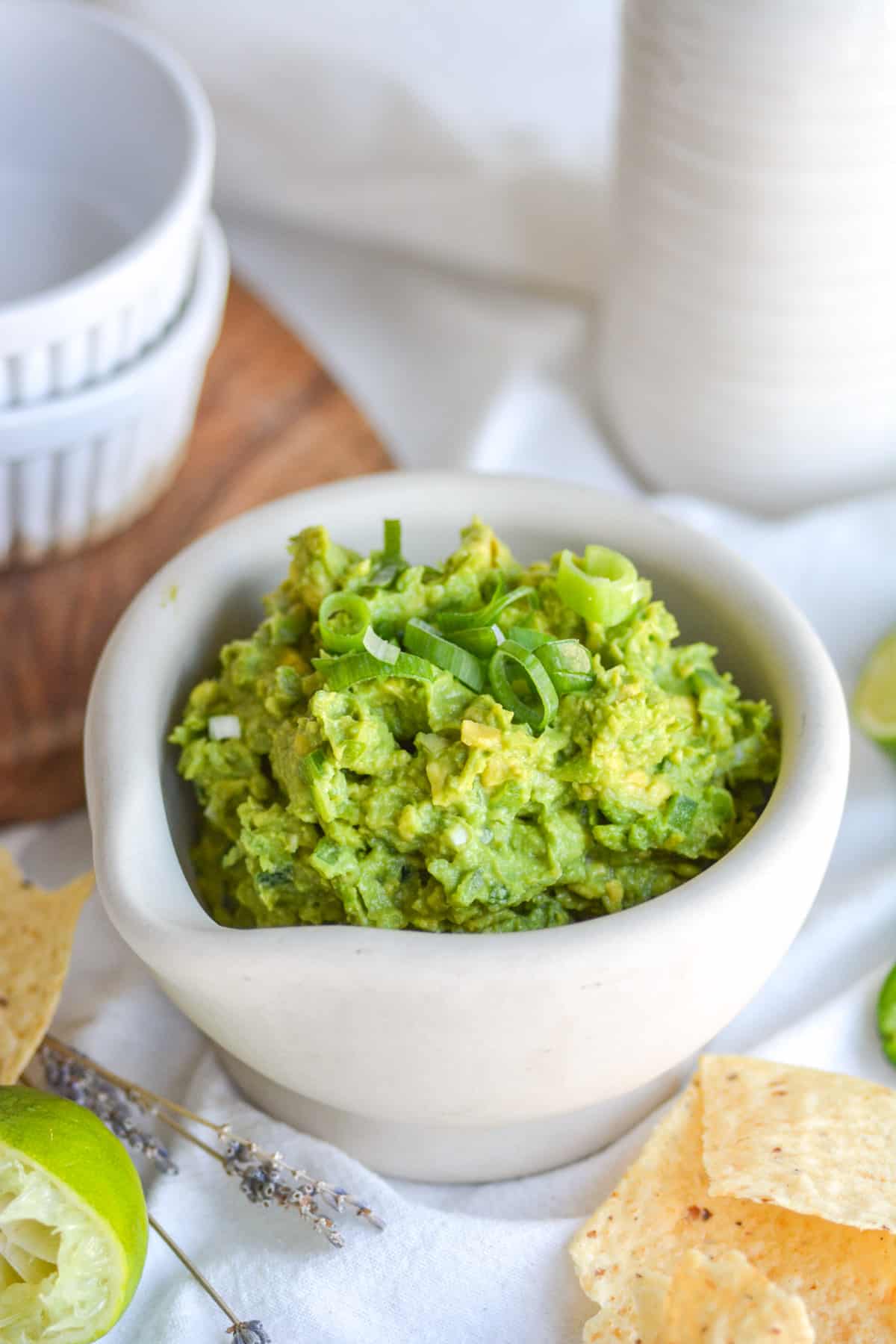 Simple 4 ingredient guacamole in a small bowl with tortilla chips in the foreground.