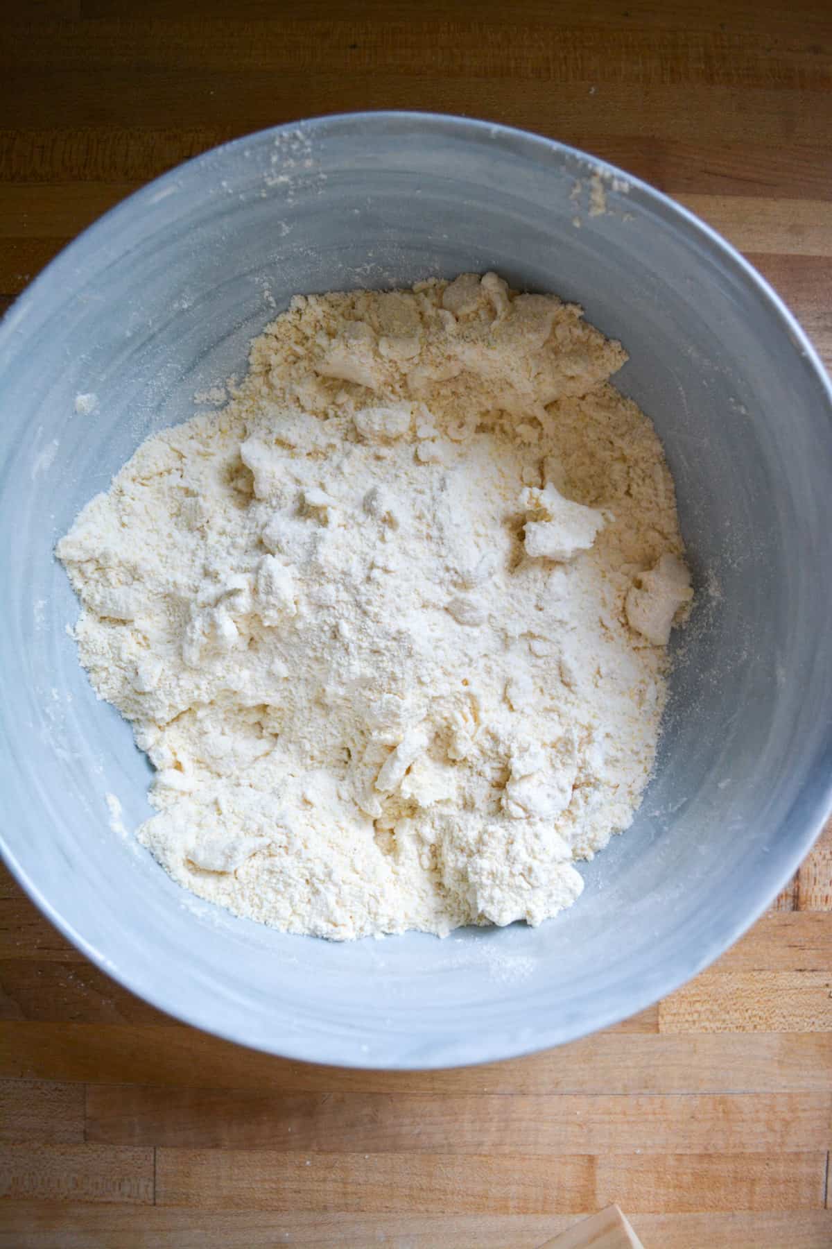 Vegan butter worked into the dry ingredients until its the size of small peas in a large mixing bowl.